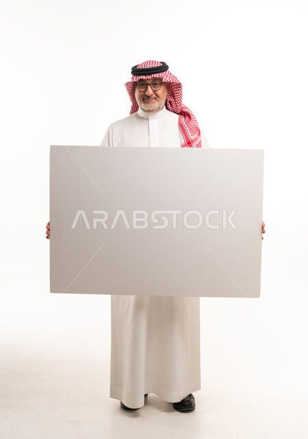 رجل سعودي يحمل لوحة فارغة على خلفية بيضاء