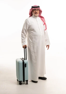 رجل سعودي بملابس تقليدية مع حقيبة سفر