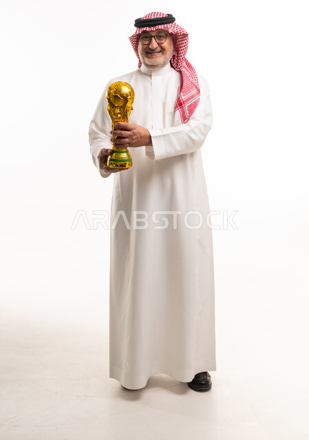 رجل سعودي يمسك بكأس العالم لكرة القدم بخلفية بيضاء