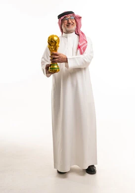 رجل سعودي مسن يمسك كأس العالم الذهبي