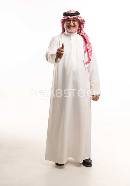 رجل سعودي بالثوب يرفع إبهامه صورة كاملة