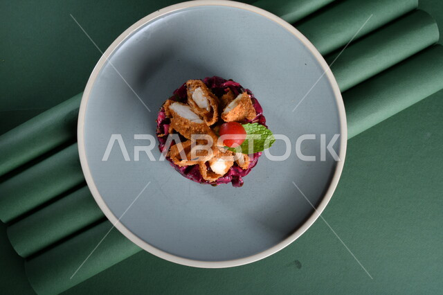 طبق سلطة الملفوف البنفسجي اللذيذ ، مزين بالدجاج المقلي المقرمش ( ناجيتس ) مصورة على خلفية خضراء ، ستيك داجاج ، مقبلات باردة ، اطباق عربية ، ماكولات شرقية ، مقبلات رمضانية ، طبق صحي ومفيد ، كروما