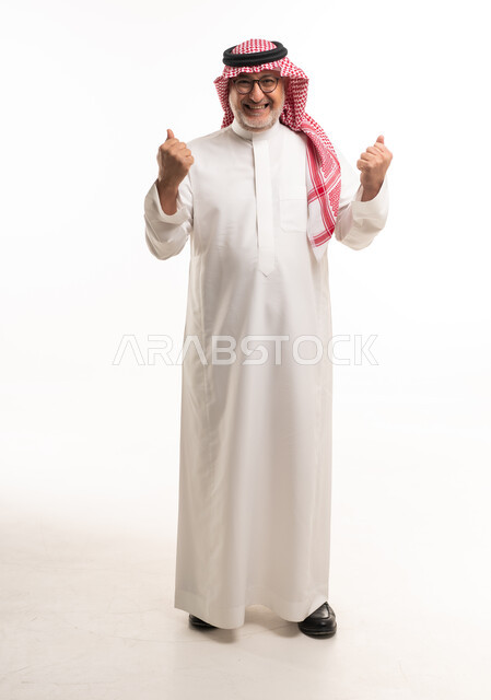 رجل سعودي مسن بالزي التقليدي يعبر عن النجاح