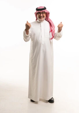 رجل سعودي مسن بالزي التقليدي يعبر عن النجاح