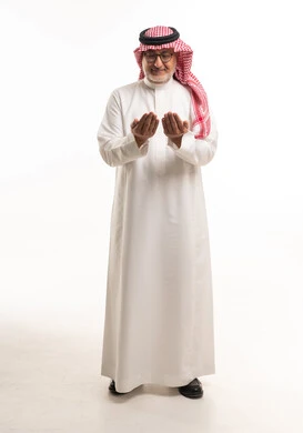 رجل سعودي مسن يدعو بالزي التقليدي