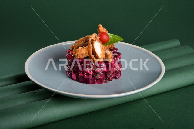 Delicious purple cabbage salad dish, decorated with crispy fried chicken (nuggets) depicted on a green background, chicken steak, cold appetizers, Arabic dishes, oriental foods, Ramadan appetizers, healthy and useful dish, chroma