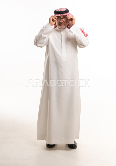 رجل سعودي كبير بالسن بالثوب التقليدي والنظارة
