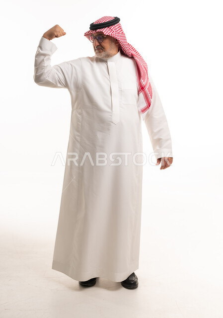 رجل سعودي مسن يستعرض عضلاته بخلفية بيضاء