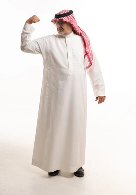 رجل سعودي مسن يستعرض عضلاته بخلفية بيضاء