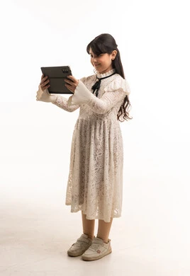 Saudi Girl in White Lace Dress Using Digital Tablet