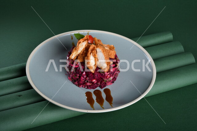 طبق سلطة الملفوف البنفسجي اللذيذ ، مزين بالدجاج المقلي المقرمش ( ناجيتس ) مصورة على خلفية خضراء ، ستيك داجاج ، مقبلات باردة ، اطباق عربية ، ماكولات شرقية ، مقبلات رمضانية ، طبق صحي ومفيد ، كروما