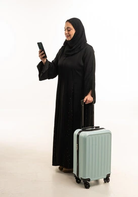 Saudi Woman in Black Abaya Holding Suitcase and Phone