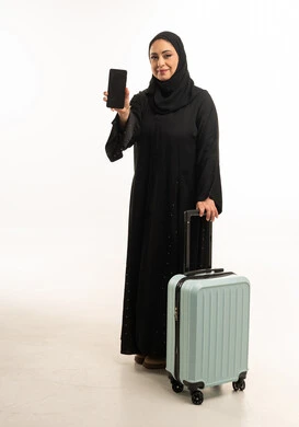 Emirati Woman with Travel Suitcase Holding Smartphone