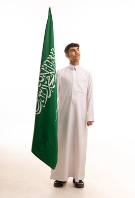 Saudi Man Holding National Flag in Traditional Thobe
