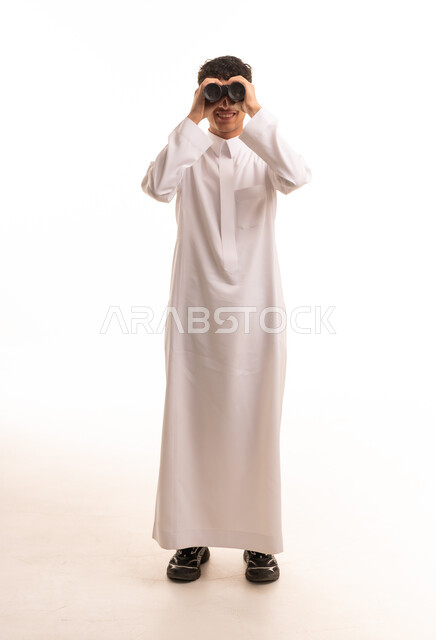 رجل سعودي بالثوب الأبيض يستخدم المنظار خلفية بيضاء