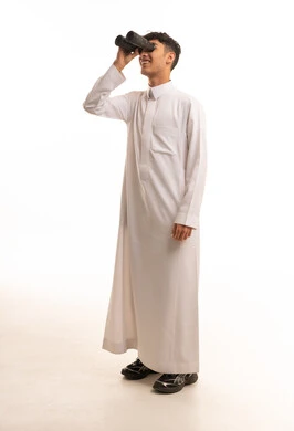 شاب سعودي بالثوب التقليدي ينظر من خلال المنظار شاب سعودي بالثوب التقليدي ينظر من خلال المنظار