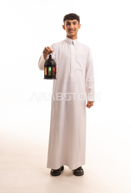 شاب سعودي بالثوب الأبيض يحمل فانوس رمضان