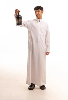 شاب سعودي بالثوب التقليدي يحمل فانوس رمضان