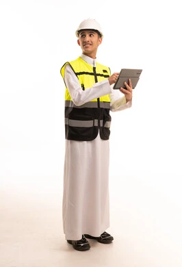 مهندس سعودي يرتدي سترة السلامة ويستخدم جهاز لوحي