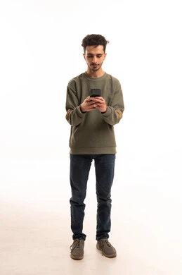 شاب سعودي يستخدم الهاتف الذكي على خلفية بيضاء