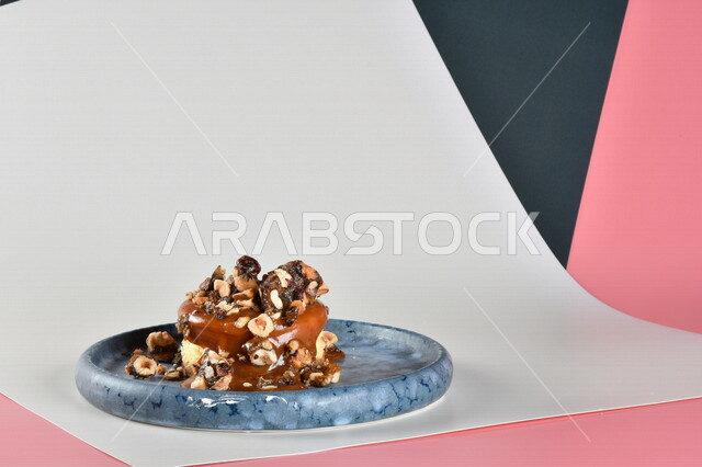 طبق من الحلا البارد مزين بالكراميل والبندق اللذيذ ، حلا شرقي ، حلويات رمضانية ، حلويات وسكريات ، قطع الحلوى الشهية ، التحلاية ، حلويات باردة لذيذة