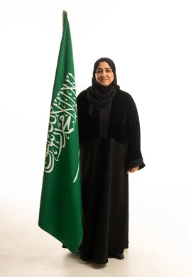 امرأة سعودية مع العلم الوطني في الاستوديو