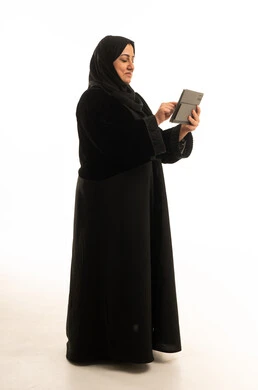 Saudi Woman in Black Abaya Using Tablet on White