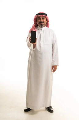 رجل سعودي يحمل هاتف ذكي بخلفية بيضاء