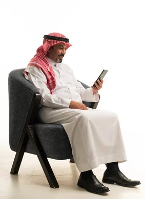 رجل سعودي يستخدم الهاتف الذكي بخلفية بيضاء