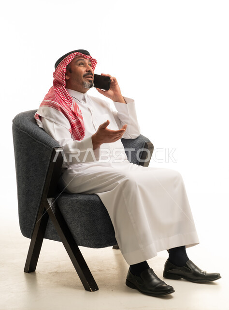 رجل سعودي بالزي التقليدي يتحدث عبر الجوال