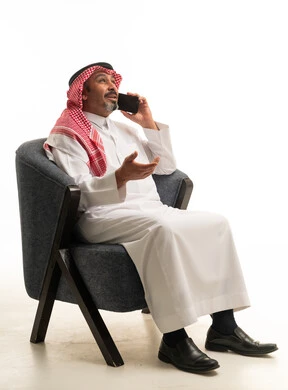 رجل سعودي بالزي التقليدي يتحدث عبر الجوال
