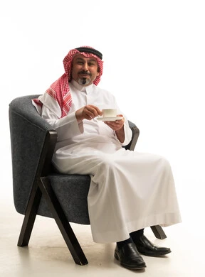رجل سعودي بالزي التقليدي يحمل فنجان قهوة