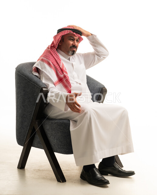 رجل سعودي بالثوب التقليدي يعاني من الصداع