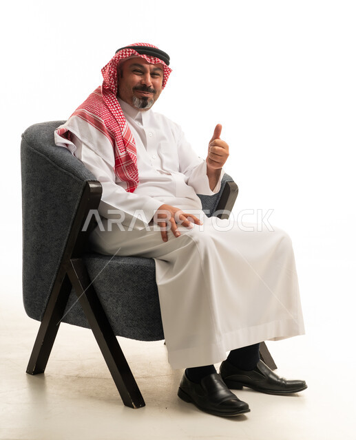 رجل سعودي بالزي التقليدي يشير بعلامة الإعجاب