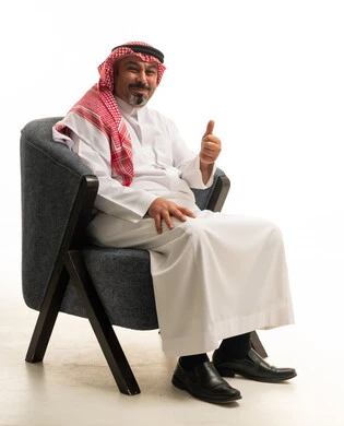 رجل سعودي بالزي التقليدي يشير بعلامة الإعجاب