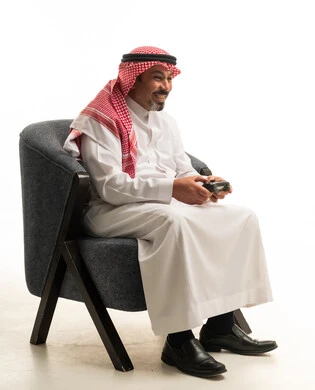 Saudi Man Playing Video Games in Traditional Thobe