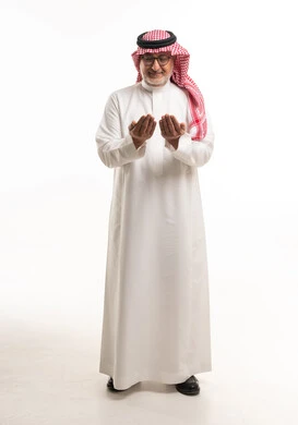 رجل سعودي مسن يدعو بالزي الشعبي التقليدي