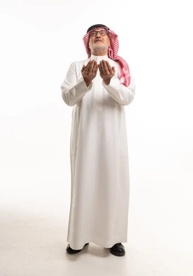 رجل سعودي بالزي التقليدي يرفع يديه بالدعاء خلفية بيضاء