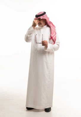 رجل سعودي مسن يعاني من الصداع بالزي التقليدي