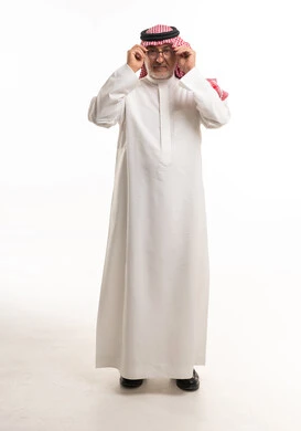 رجل سعودي مسن يرتدي الثوب والنظارات في استوديو