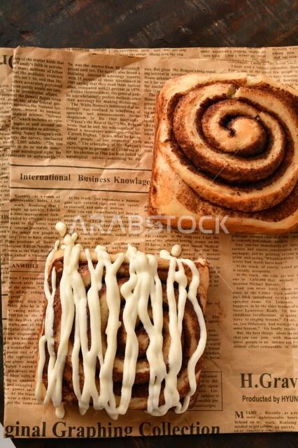 صورة مقربة للفائف القرفة اللذيذة مع الصوص الابيض، لفائف السينابون، معجنات، سينابون رول ، مخبوزات طازجة، لفائف الحلوى الشهية 