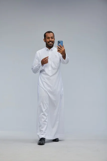 رجل سعودي بالثوب الأبيض يلتقط سيلفي بالهاتف