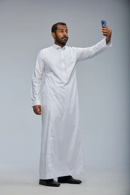 Saudi Man in White Thobe Taking Smartphone Selfie Studio