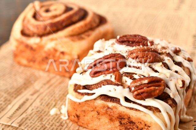 Close-up of delicious cinnamon rolls with white sauce, cinnabon rolls, pastries, cinnabon rolls, freshly baked bread, delicious dessert rolls