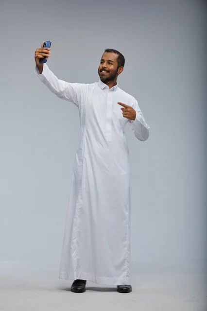 Saudi Man in White Thobe Taking Selfie in Studio
