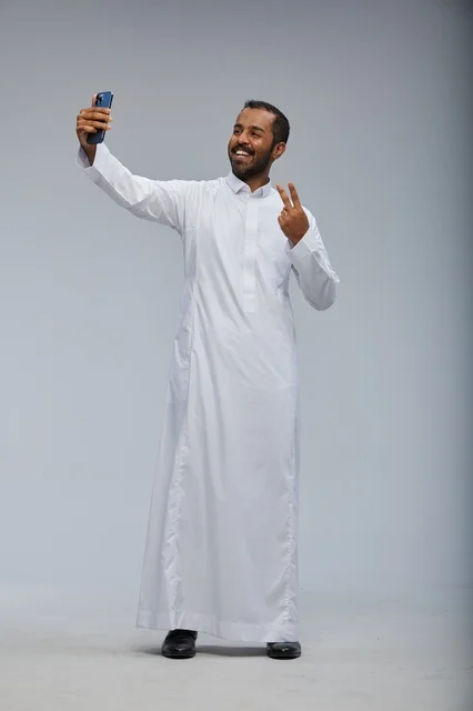 رجل سعودي بالثوب الأبيض يلتقط صورة سيلفي