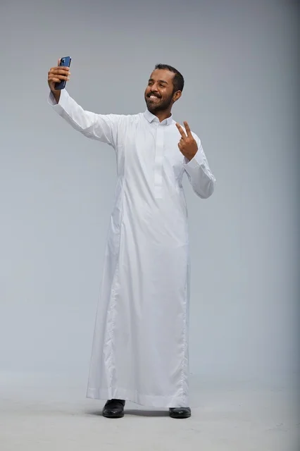 Saudi Man in White Thobe Taking Smartphone Selfie
