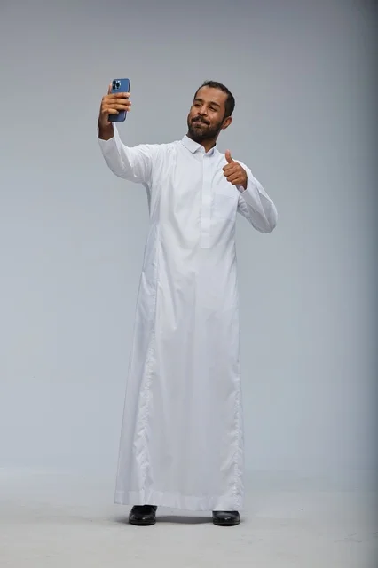 Saudi Man in White Thobe Taking Smartphone Selfie Studio