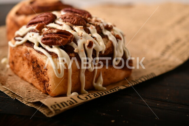 Close-up of delicious cinnamon rolls garnished with walnuts and white sauce, cinnabon rolls, pastries, cinnabon rolls, fresh baked goods, delicious dessert rolls