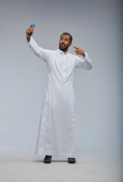 Saudi Man in White Thobe Taking Selfie in Studio